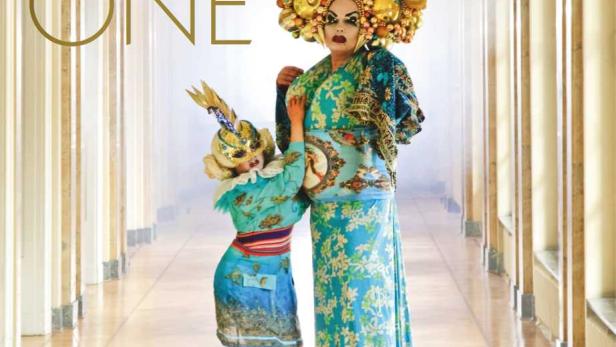 Das Filmplakat zu „One Zero One“ zeigt zwei extravagante Figuren in einem hellen Gang.