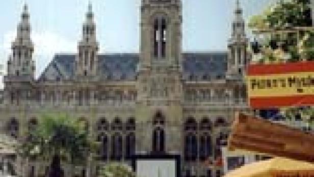 Das Wiener Rathaus überblickt einen belebten Markt mit Essensständen.