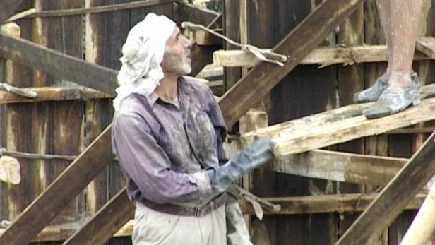 Ein Bauarbeiter mit Turban arbeitet an einer Holzkonstruktion.