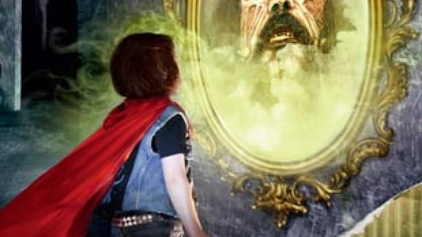 Ein Junge mit rotem Umhang steht vor einem Spiegel, in dem ein Monster zu sehen ist.