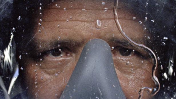 Nahaufnahme des Gesichts einer Person mit Taucherbrille unter Wasser.