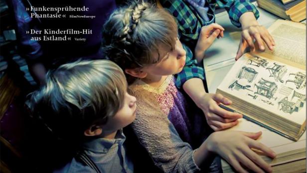 Vier Kinder beugen sich über ein aufgeschlagenes Buch mit Zeichnungen in dem Filmplakat zu „Der Geheimbund von Suppenstadt“.