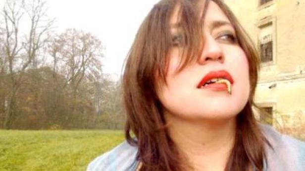 Eine Frau mit roten Lippenstift hat eine Made im Mund.