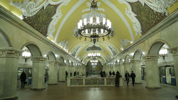 Die kunstvoll gestaltete Station Komsomolskaja der Moskauer Metro mit Menschen auf dem Bahnsteig.