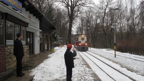 Ein Zug nähert sich dem Bahnhof Virágvölgy im Winter.