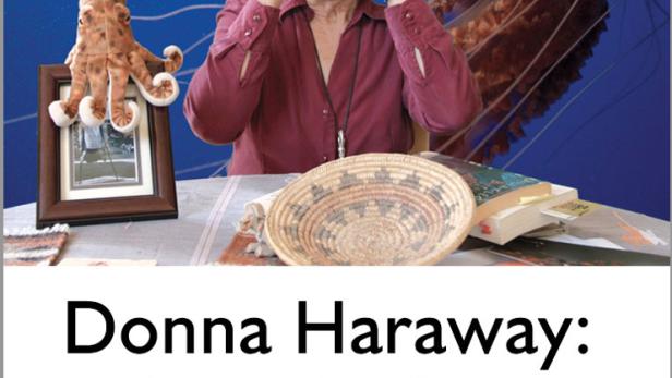 Donna Haraway macht eine Geste vor einem Hintergrund mit einer Qualle und einem Tintenfisch.