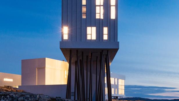 Das Fogo Island Inn, ein modernes Hotel auf Stelzen, bei Dämmerung.