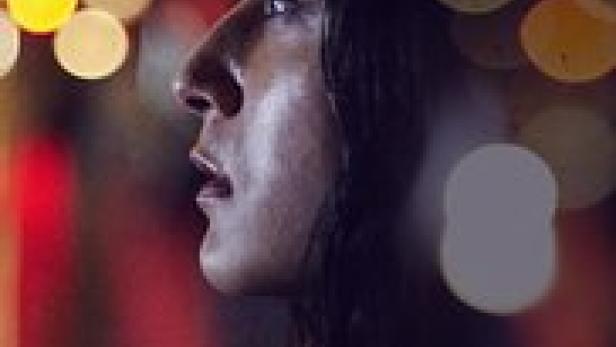 Das Filmplakat für „Raniya“ zeigt eine Frau vor einem verschwommenen Hintergrund aus Lichtern.