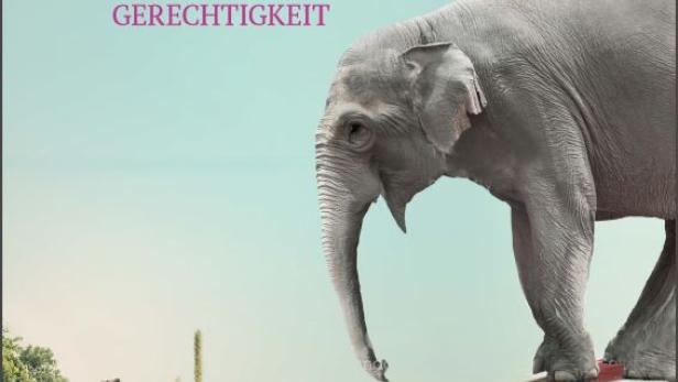 Ein Elefant balanciert auf einer Wippe über einer Blumenwiese mit einer Stadt im Hintergrund.