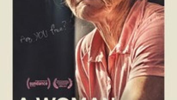 Das Filmplakat für „A Woman Captured“ zeigt eine ältere Frau in einem rosa Hemd.