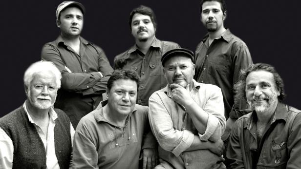 Ein Schwarzweißfoto einer Gruppe von sieben Männern unterschiedlichen Alters.