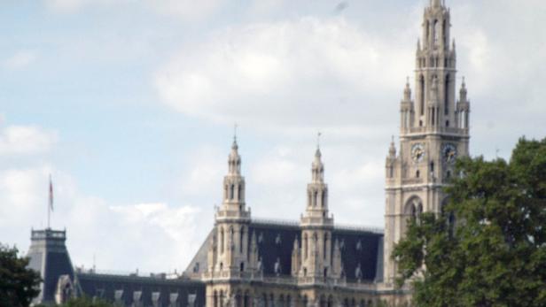 Das Wiener Rathaus mit seinem markanten Turm, gesehen durch Bäume.
