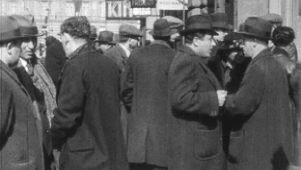 Eine Menschenmenge steht auf einer Straße in einer Stadt.