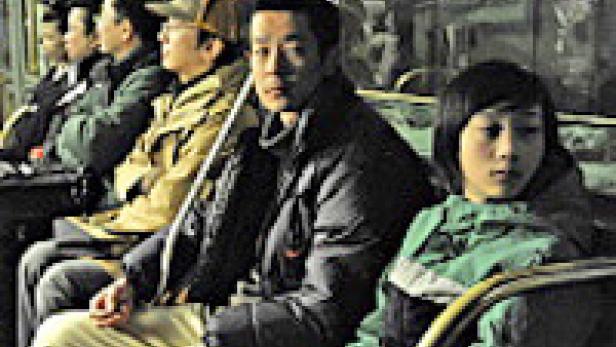 Mehrere Menschen sitzen in einem Bus und schauen aus dem Fenster.