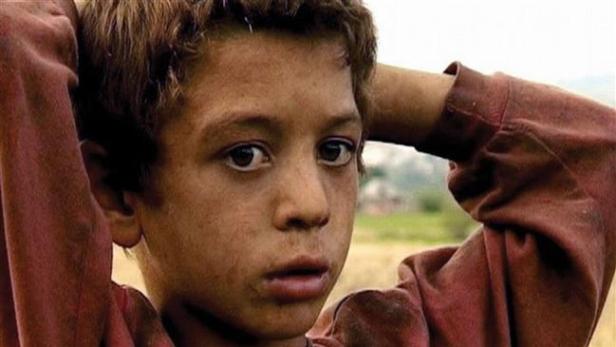 Ein junger, nachdenklicher Junge mit den Händen hinter dem Kopf.