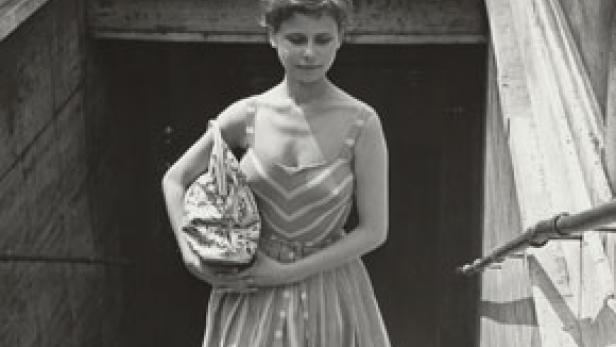 Eine junge Frau in einem gestreiften Kleid verlässt eine U-Bahn-Station.