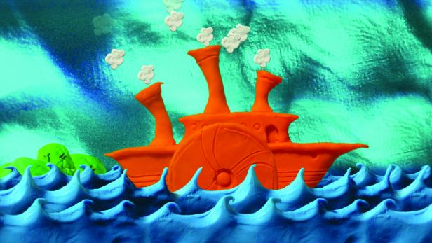 Ein orangefarbenes Raddampfer-Modell aus Knete auf blauem, gewelltem Untergrund.