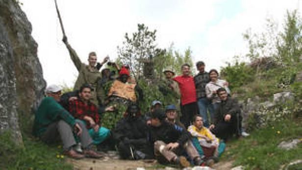 Eine Gruppe von Menschen posiert für ein Foto in einer felsigen Umgebung.