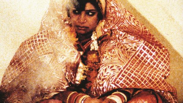 Eine indische Braut mit traditionellem Hochzeitsschmuck und rotem Sari.