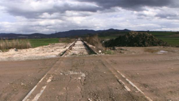 Eine stillgelegte Eisenbahnstrecke führt durch eine ländliche Gegend.