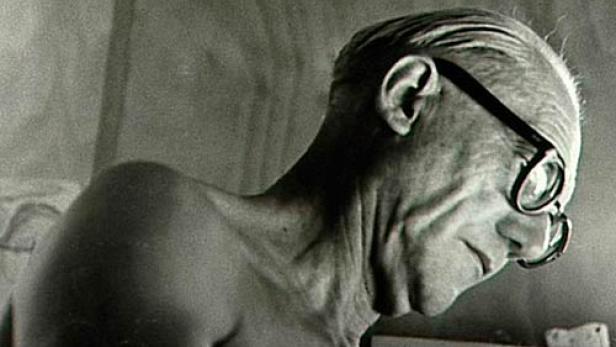 Ein älterer Mann mit Brille blickt nach unten.