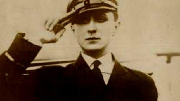 Ein junger Mann in Marineuniform salutiert.