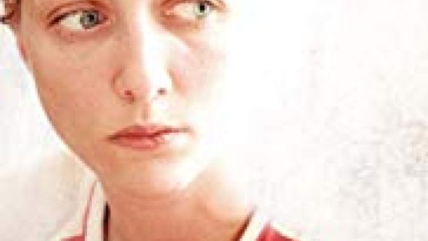 Das Filmplakat für „Irina“ zeigt das Porträt einer jungen Frau mit roten Haaren.