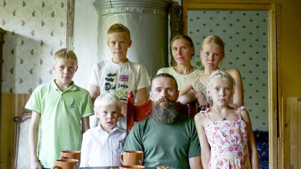 Eine Familie posiert in einem ländlichen Haus für ein Gruppenfoto.