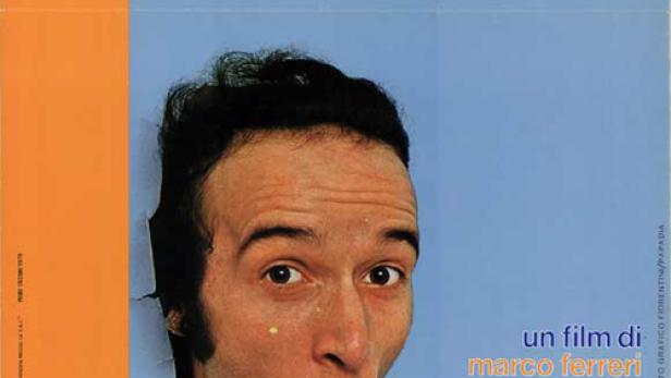 Das Filmplakat für „Chiedo Asilo“ zeigt Roberto Benigni, der überrascht aus einer Wand schaut.