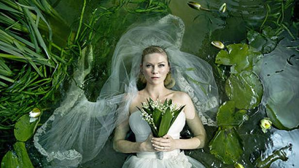 Kirsten Dunst als Braut treibt im Wasser, Lilien haltend.