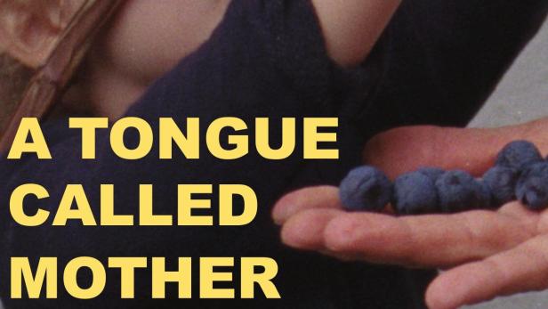 Ein kleines Mädchen betrachtet neugierig eine Handvoll Blaubeeren.