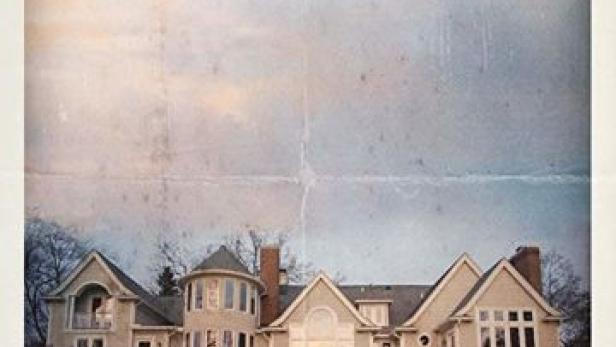 Das Filmplakat für „New Money“ zeigt ein Paar vor einem großen Haus.