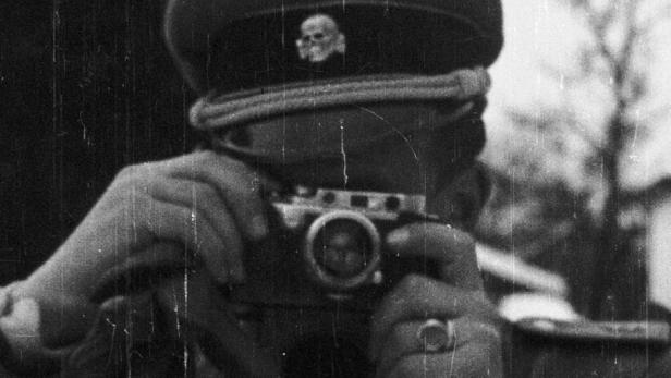 Das Filmplakat für „Eine Eiserne Kassette“ zeigt einen Mann in Uniform mit einer Kamera.