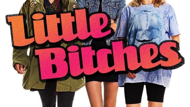 Drei junge Frauen stehen vor dem Schriftzug „Little Bitches“.