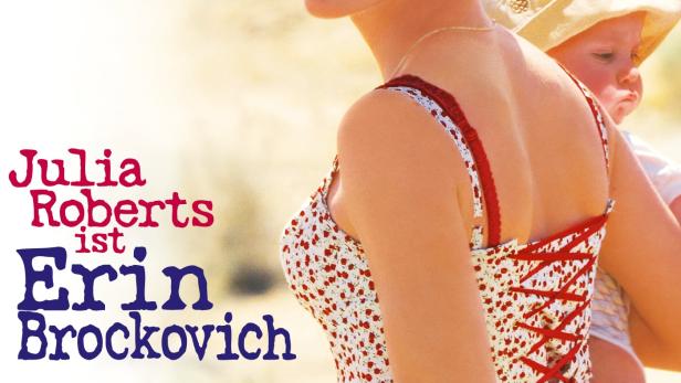 Julia Roberts als Erin Brockovich mit einem Kind auf dem Arm.