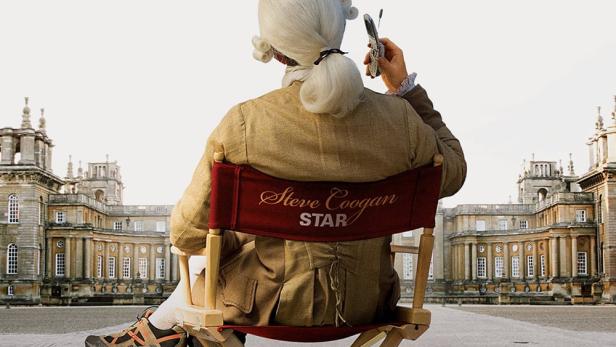 Das Filmplakat für „Tristram Shandy: A Cock and Bull Story“ zeigt Steve Coogan mit Handy auf einem Regiestuhl.