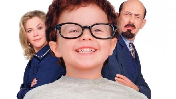 Das Filmplakat für „Baby Geniuses“ zeigt ein lächelndes Kind mit Brille vor zwei Erwachsenen.