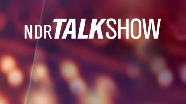 Logo der „NDR Talkshow“ vor einem unscharfen, farbigen Hintergrund.