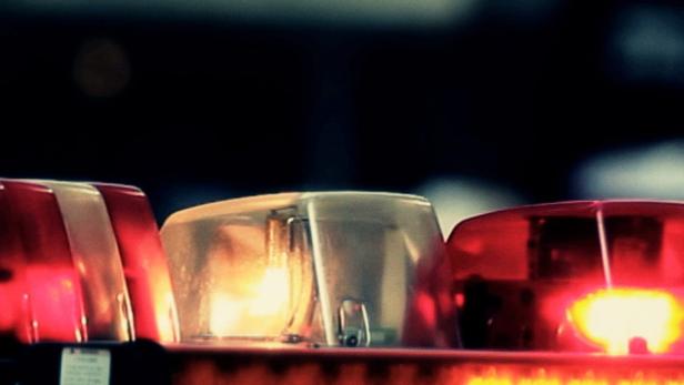 Das Logo der Fernsehserie „Cops“ über dem Blaulicht eines Polizeiautos.