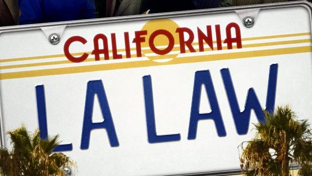Das Poster der Fernsehserie „L.A. Law“ mit den Hauptdarstellern vor einer kalifornischen Stadtlandschaft.