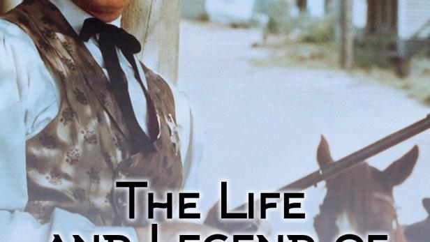 Ein lächelnder Mann im Western-Outfit, vermutlich aus der Serie „The Life and Legend of Wyatt Earp“.