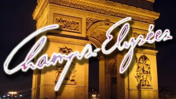 Der Arc de Triomphe in Paris bei Nacht mit Lichtspuren vorbeifahrender Autos.