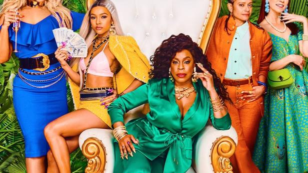 Fünf Frauen posieren vor einem tropischen Hintergrund für ein Werbeplakat der Serie „Claws“.