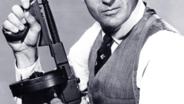 Ein Mann im Anzug hält eine Thompson-Maschinenpistole, im Stil der Fernsehserie „Die Unbestechlichen“.