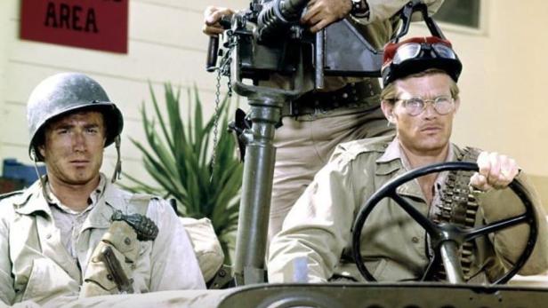 Drei Männer in Uniform in einem Jeep, Szene aus der Fernsehserie „The Rat Patrol“.
