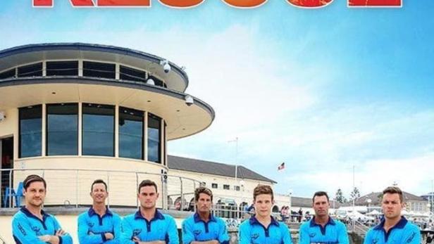 Die Rettungsschwimmer von „Bondi Rescue“ posieren am Strand vor ihrem Gebäude.