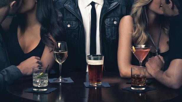 Der Comedian Stephen Merchant steht inmitten von zwei turtelnden Paaren an einer Bar, wie im Filmposter von „Hello Ladies“.
