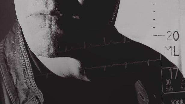 Das Gesicht eines Mannes überlagert mit medizinischen Anzeigen und dem Titel „Complications“.