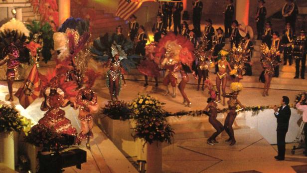 Die Show „Stars 90“ mit Tänzern, Musikern und Publikum auf einer beleuchteten Bühne.