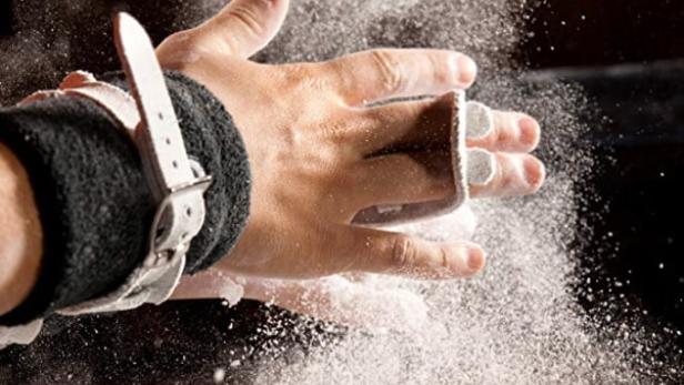 Die Hände eines Turners sind mit Magnesiumpulver bedeckt.